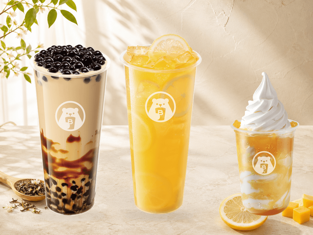 BINGXUE milk tea, lemon fruit tea and mango sundae on a cream table in warm natural light